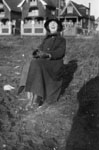 Woman seated in front of row of houses