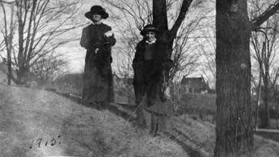 Two women posed by trees