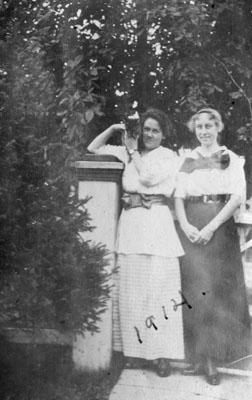 Two young women standing in garden