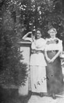 Two young women standing in garden