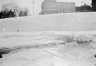 Ice-covered 16 mile creek with Commercial hotel in background.