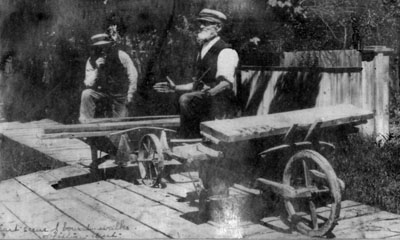 Walter Pitcher and Tommy Turner repairing plank sidewalks on Main Street.