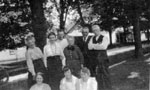 Family group standing in front of cottages in Brussels, Ontario.