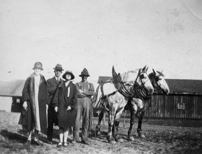 Two men and two women posed with horses