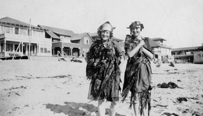 Two ladies in fancy dress standing on beach