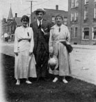 Man and two women posed on street
