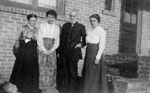 Group posed by house