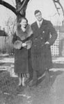 Man and woman in winter clothing standing in garden