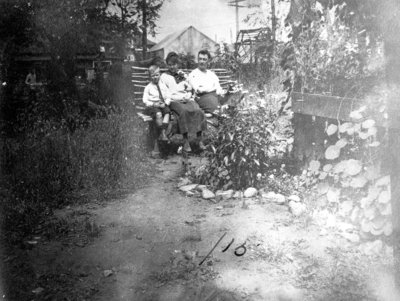 Man, woman and boy sitting in garden