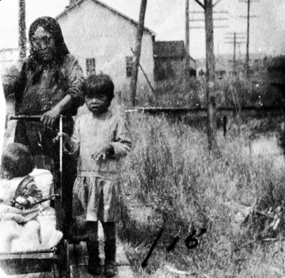 Woman pushing stroller with infant.