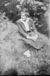 Woman sitting on river bank