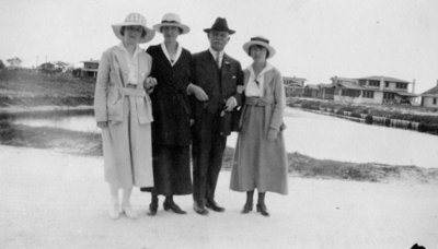 Man and wife with two younger women standing on a beach