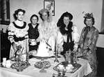 A group of women in period costumes at English style tea party