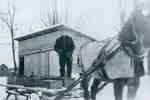 Delivering milk on a horse drawn sled in winter