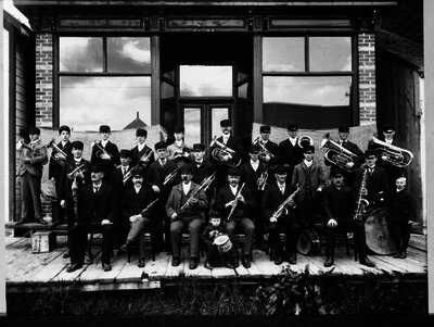 Band posed outside storefront, Norwich