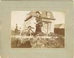 Photograph of a man on bicycle with a child