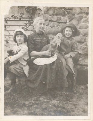 Photograph of a woman with two girls and a cat