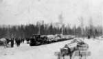 Loggers pulling a load of logs on a sled with a snowcat