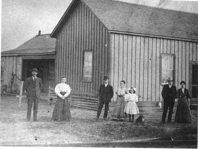 Men, Women and Child in Front of Building