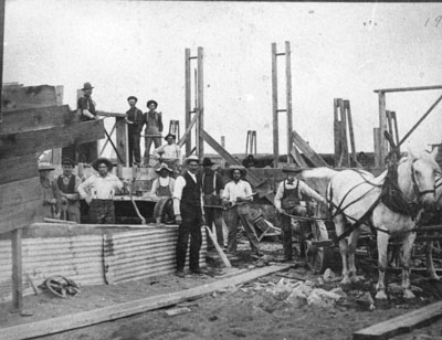 Men and a horse at a building constructing