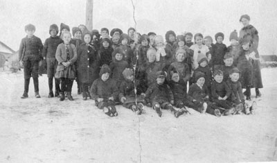 School Students Sitting in the Snow with their Teacher, circa 1920