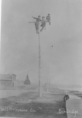 Men on-top of a Bell Telephone Company pole, circa 1910
