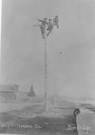 Men on-top of a Bell Telephone Company pole, circa 1910