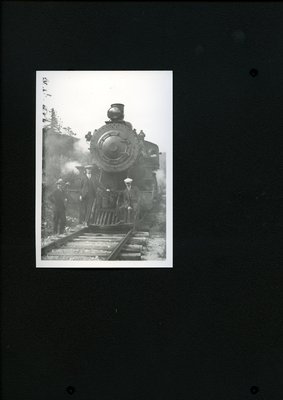 Photograph of men posing with a locomotive in the 1920s
