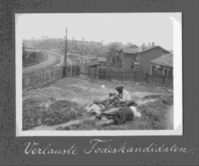Three women resting in a grassy area near some houses and a factory