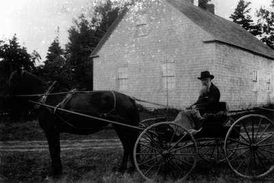 Mr. Crew - old Cavendish mailman, sitting in a buggy in front of Cavendish Homestead, ca.1890's.  Cavendish, P.E.I.