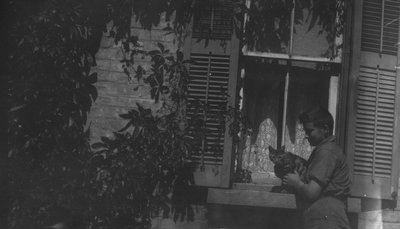 Chester holding cat on window ledge, Leaskdale, ON.