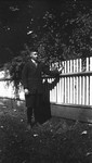 Chester standing beside garden fence.