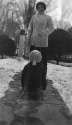 Chester on a toboggan with unidentified woman, Leaskdale, ON.