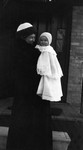 Chester in his 1st coat at 7 months.  Held by Mrs. Mustard, ca.1912.  Leaskdale, ON.