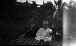 Stuart as a baby sitting on a rug in the garden, Leaskdale, ON.