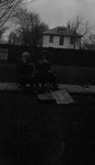 Stuart and a friend sitting on a cart in the garden, Leaskdale, ON.