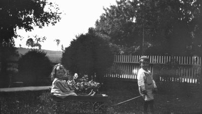 Stuart pulling Ruth Cook in wagon, ca.1919.  Leaskdale, ON.