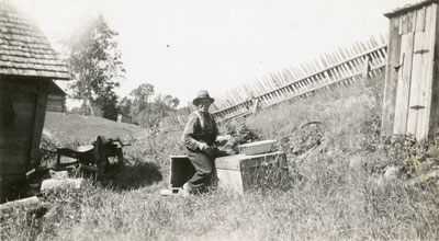 John F McAmmond filleting fish, McAmmond Homestead, Deer River, 1941