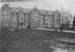 Waterloo College students playing baseball in front of Willison Hall