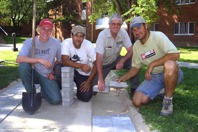 Four men laying paving stones at Wilfrid Laurier University