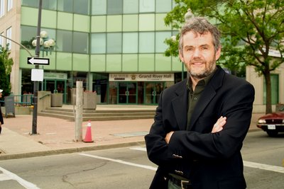 Leo Groarke standing in front of Grand River Hall, Laurier Brantford