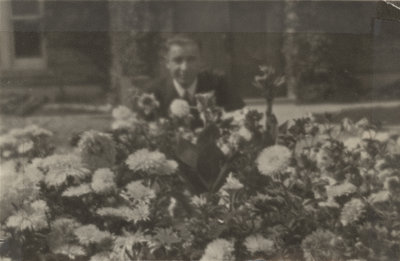 Earle Shelley behind flowerbed, 1921