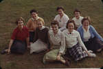 Eight female Waterloo Lutheran University students sitting on the grass