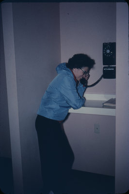 Woman using the telephone in Conrad Hall, Waterloo Lutheran University