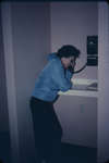 Woman using the telephone in Conrad Hall, Waterloo Lutheran University
