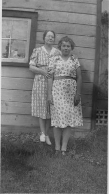 Two women standing in front of a building