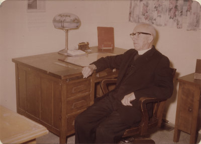 Reverend John Kirchhofer sitting at desk