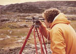 Researcher using survey equipment
