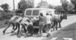 People pushing the Lutheran Summer Camps van