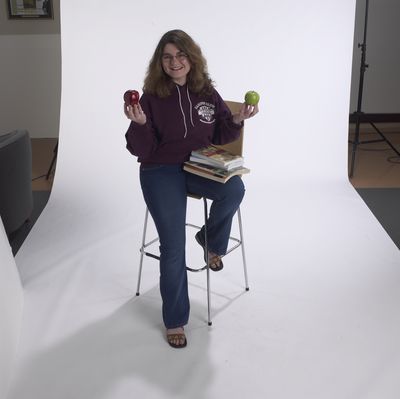 Student posing holding apples, 2002